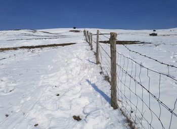 Snow covered field against sky