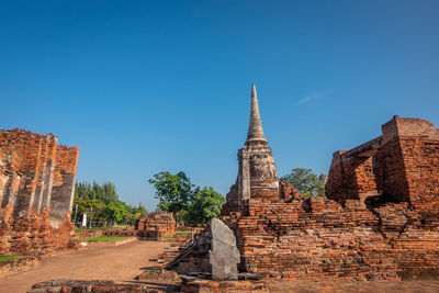 Old temple building against clear blue sky