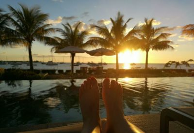 Low section of woman relaxing by swimming pool