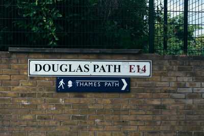 Low angle view of information sign on brick wall