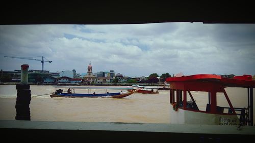 View of cityscape against cloudy sky