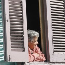 Side view of woman looking through window