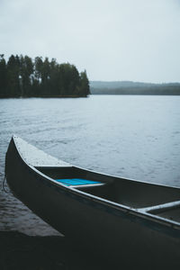 Boat moored in lake against sky