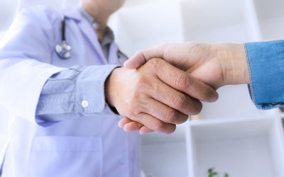 Close-up of doctor and patient shaking hands