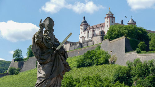 Low angle view of statue against sky festung marienberg in würzberg, germany