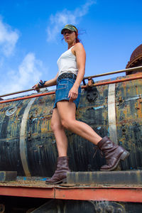 Low angle view of woman standing against sky