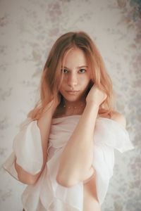 Portrait of young woman sitting on bed at home