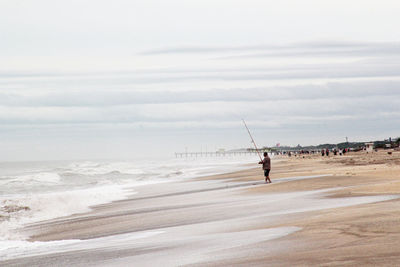 Fishermen on the beach, details of bait and lines of fishing rods.man on beach against sky