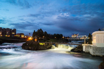 Illuminated city at waterfront during winter