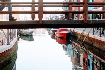 Boats moored in canal by buildings