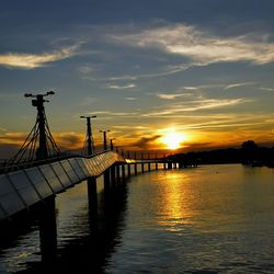 Pier over sea against sky during sunset