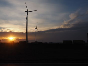 Silhouette of wind turbines at sunset