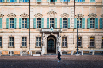 Full length of woman standing by building in city