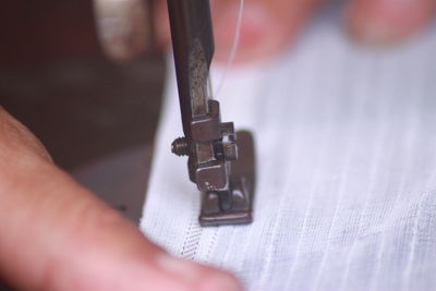 Cropped hand of person repairing machine