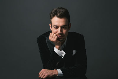 Portrait of young man against black background