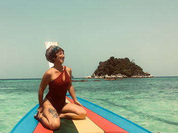 Rear view of woman sitting in swimming pool