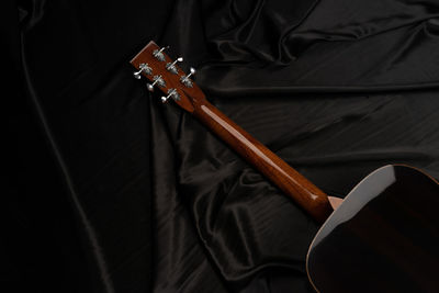 Close-up of acoustic guitar on bed