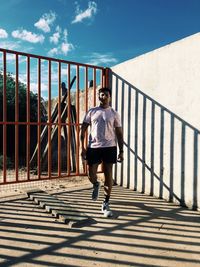 Portrait of man standing by metal fence