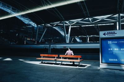 Rear view of man sitting on bench
