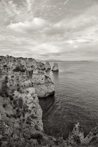 Scenic view of cliff by sea against sky