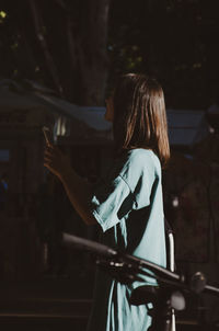 Side view of woman standing at home