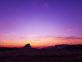 Scenic view of silhouette field against sky during sunset