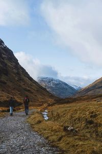 Rear view of people on mountain against sky