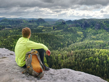 Spring rocky mountains. hiker with backpack stand on rocky view point. copy space. active lifestyle