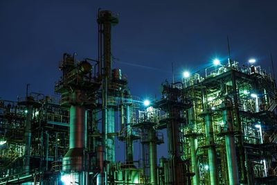 Low angle view of illuminated oil industry at night