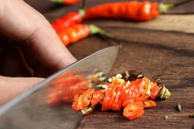 Cropped hand chopping red chili