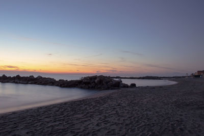 Scenic view of beach against sky during sunset