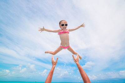 Low angle view of girl in mid air against sky