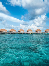 Buildings by sea against sky