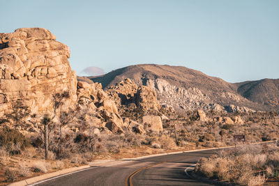 Road leading towards mountains against sky