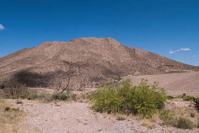 Scenic view of arid landscape against clear blue sky