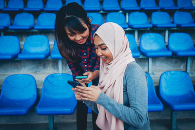 Full length of young woman using mobile phone