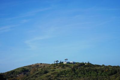 People on mountain against blue sky