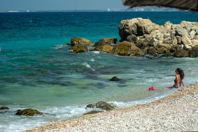 People on rocks at sea shore