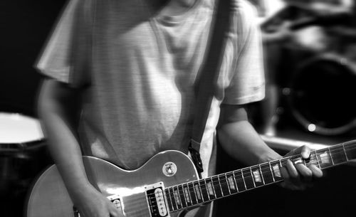 Midsection of man playing guitar