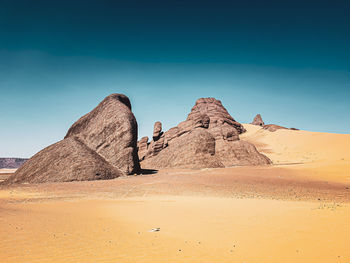 Scenic view of desert against clear blue sky