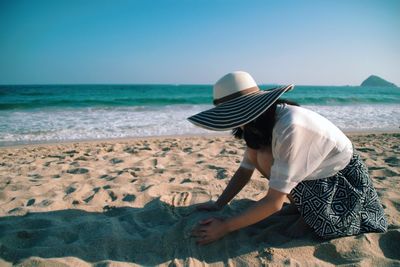 Woman playing on beach against sea