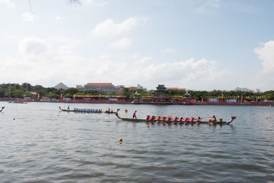 People in boat on river against sky