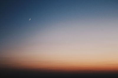 Low angle view of silhouette moon against sky at sunset