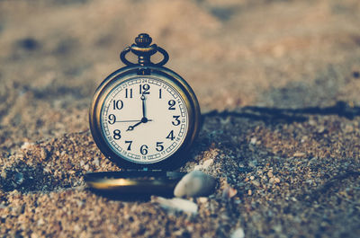 Close-up of pocket watch at beach