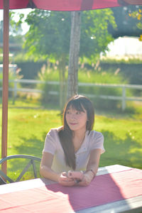 Portrait of young woman sitting on field