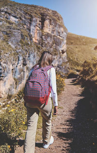 Young tourist walks on a path to the mountain. adventure travel, hiking concept.