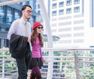 Couple walking on elevated walkway at airport