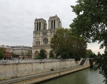 View of building by river against sky