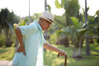 Side view of senior man standing at field