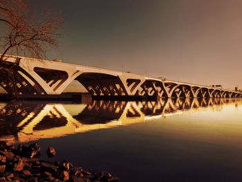 Bridge over river against sky at night